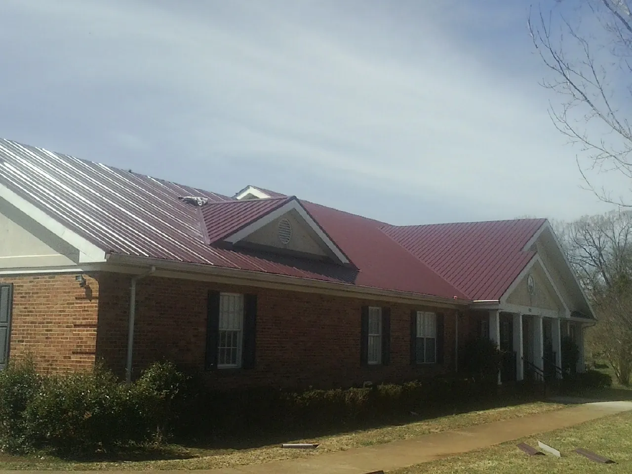 Red metal roof with gabled entries on a long brick building in Arapahoe