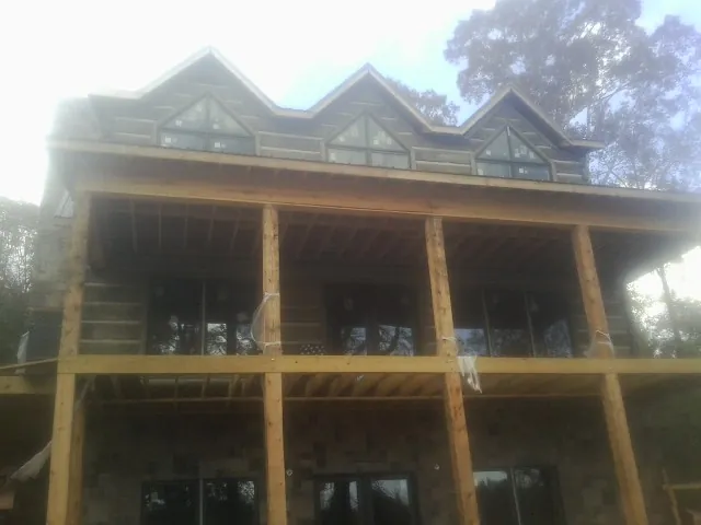 Dormers and porch framing on a large log home under construction — Roof Coating work by our crew in Arapahoe