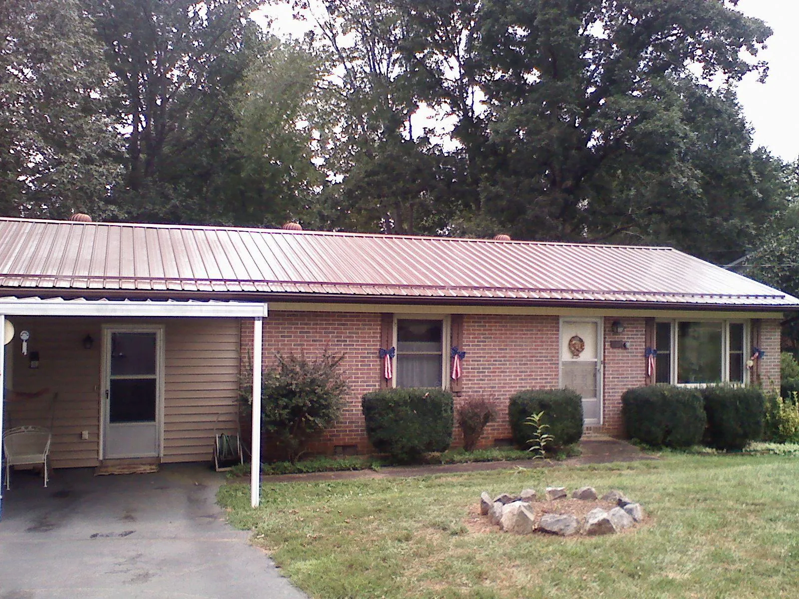Bronze metal roof and carport on a brick ranch home — Roof Repair work by our crew in Arapahoe